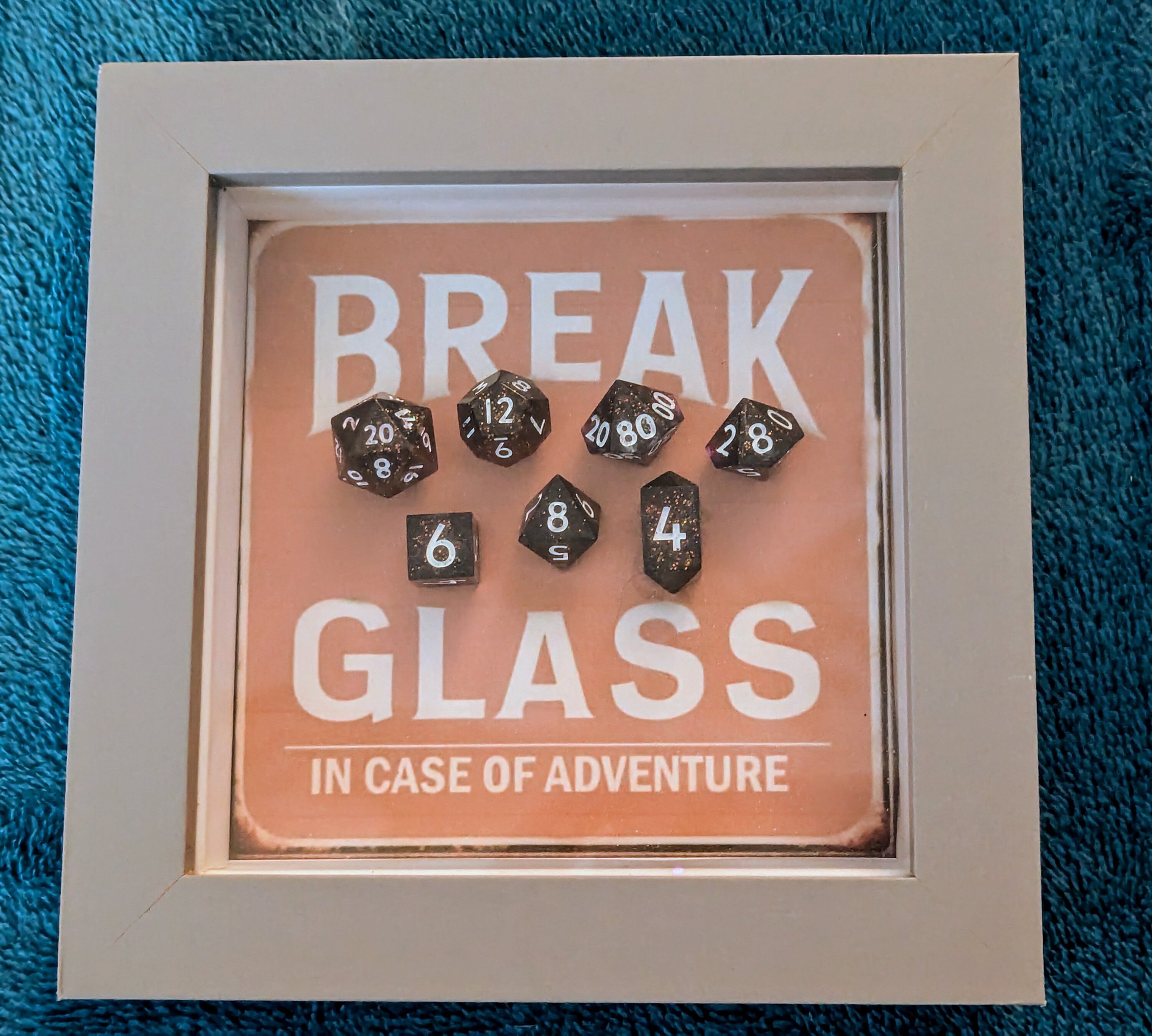 Wall Art Box Frame that has a vintage sign style background and says Break Glass in case of Adventure with a set of 7 polyhedral Dice inside.
